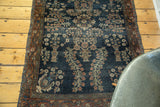 Antique Farahan Sarouk rug's navy field, floral vase motifs, burnt brick border, and wear.