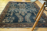 Corner of antique transitional Farahan Sarouk rug: burnt brick border, navy field, floral patina.