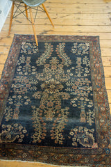 Antique Sarouk rug corner with burnt brick border, navy field floral vase, and fringe.