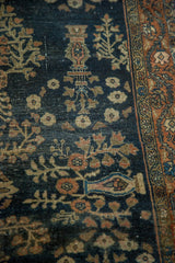 Antique Farahan Sarouk rug: navy field, floral and tree motifs, burnt brick border, wear.