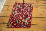 Antique Kerman fragment with intricate floral and scrolling vine motifs on ruby red.
