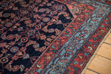 Corner view showing the sky blue border next to the navy Herati field of a vintage Engelas rug.