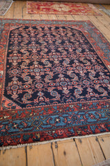 Angled view of a vintage Engelas rug highlighting the wool's high luster and navy Herati pattern.