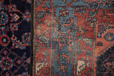 Detail showing professional restoration on the Persian rug's sky blue and red border.