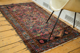 Dense allover Herati pattern in ruby purple field and brilliant blue border section.