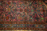 Ruby purple herati design, brilliant blue border, and fringe of a vintage Lilihan rug.