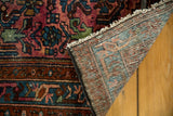 Vintage Lilihan rug close-up: ruby purple herati pile, fringe, and woven foundation detail.