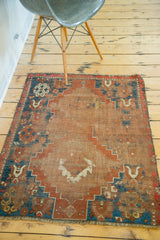 Antique Caucasian rug corner with distinct geometric nomadic motifs and flat distressed texture.