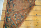 Distressed antique Caucasian rug's flat pile and geometric patterns, revealing red wefting.