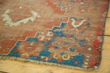 Worn fringe and distressed geometric patterns in blue, rust, cream on antique Caucasian rug.