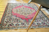 Raspberry vintage Meshed rug with ivory border, slate blue corner spandrel, and ornate golden medallion.