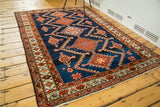 Vintage Persian rug showing indigo field with rectilinear medallions and abrash.