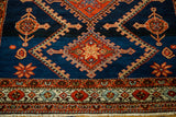 Vibrant serrated medallions on indigo field, detailed border, and short white fringe.