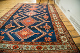 Deep indigo field with brilliant orange serrated medallions and intricate borders on a vintage Persian rug.
