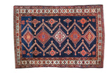 Vintage Northwest Persian rug, deep indigo field, rectilinear serrated medallions, orange, sky blue, saffron.