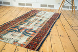 Antique Lilihan runner's distressed ivory foundation with faded blue and rust patterns.