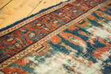 Textured distress on an antique Lilihan runner, showing ivory foundation and patterned border.
