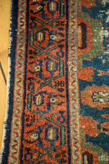 Distressed rust, blue, and green geometric border of an antique Lilihan runner.