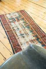 Storied antique Lilihan runner showing ivory foundation, blue and orange geometric border.