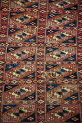 Antique Turkmen Chuval rug's fine wool guls in blue and red, showing visible wear.