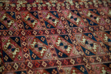 Antique Turkmen Chuval rug with repeating guls in deep red, blue, and light silk tones; aged pile texture.