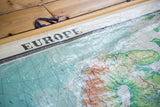 Vintage Europe map featuring relief texture, upper title, and subdued blue ocean.