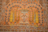 Close-up of antique Persian Tabriz tree-of-life motif in orange, yellow, and teal.