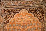 Terracotta mihrab with fine tree-of-life motif and elaborate dark borders on an antique Tabriz prayer rug.