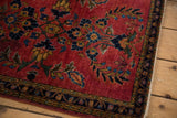 Saturated cherry red vintage Sarouk pile with intricate floral and vine patterns.