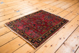 Vintage Mohajeran Sarouk rug corner showing deeply saturated maroon field and vibrant floral bouquets.