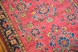Mohajeran Sarouk rug detail: deeply saturated maroon field, blue, gold floral bouquets, dark border.