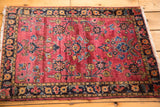 Vintage Persian Mohajeran Sarouk rug corner: saturated maroon field, navy floral border.