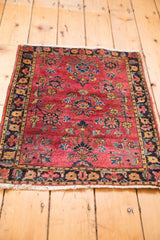 Secured white fringe and dark floral border on a deeply saturated maroon Sarouk rug.