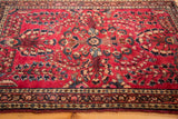 Deeply saturated cherry red field and intricate blue floral sprays on a German Sarouk rug.