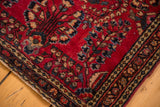 Vintage Sarouk rug's deeply saturated cherry red field, floral sprays, and intricate border detail.