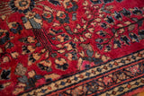 Saturated cherry red vintage German Sarouk rug, blue floral motifs, decorative border.