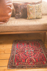 Intricate border and deeply saturated cherry red floral sprays on a vintage Sarouk rug.