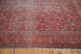 Angled close-up of the perfectly distressed pile and smokey red border of an antique rug.