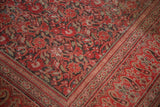 Distressed, low pile of an antique Doroksh rug showing its smokey red vine pattern.