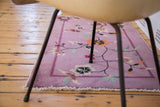 Art Deco Nichols rug in deep mauve purple with sprawling floral vines and banded border.