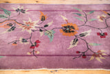 Sprawling floral vines with colorful blooms and banded border on mauve Art Deco Nichols rug.