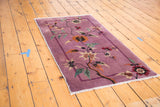 Deep mauve Art Deco vintage rug with sprawling floral vines and a thin border.