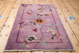 Deep mauve Art Deco Nichols rug, showing sprawling floral vines and colorful blooms.