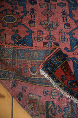 Vintage Lilihan rug corner with dusty rose field, blue Gerrus border, and white fringe.