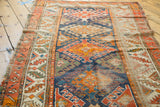 Geometric patterns and decorative textured pile in blue, orange, red on antique Caucasian runner.