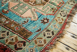 Detail of an antique Southern Caucasian rug's unique geometric outer border with abrashes and worn fringe.