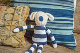 Natural toy dog with soft organic cotton texture, blue nose, and striped body.