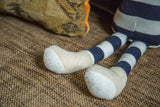 Blue and white striped organic cotton legs and beige feet of the toy dog.