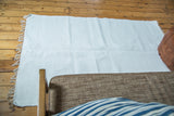 White organic cotton rag rug with textured weave and fringe detail.