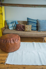 White organic cotton rag rug with handwoven texture and fringed edge.